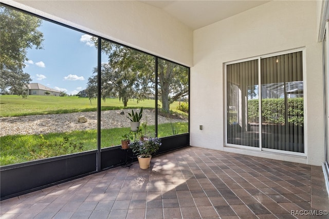 unfurnished sunroom featuring vaulted ceiling