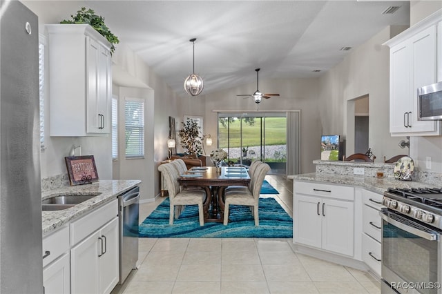 kitchen featuring ceiling fan, white cabinets, stainless steel appliances, and vaulted ceiling