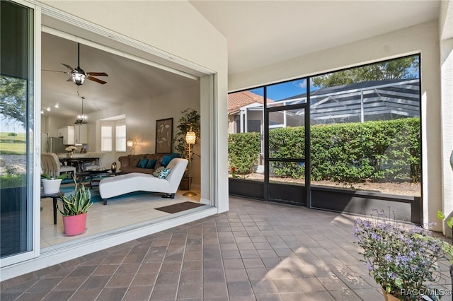 sunroom / solarium with ceiling fan, lofted ceiling, and a wealth of natural light