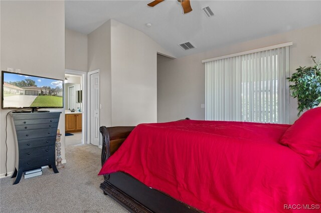 bedroom featuring vaulted ceiling, light colored carpet, ensuite bath, and ceiling fan