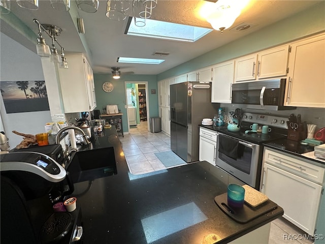 kitchen with white cabinets, stainless steel appliances, and a skylight