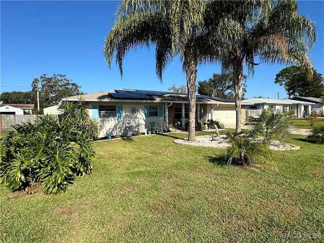 view of front facade featuring solar panels, a garage, and a front lawn