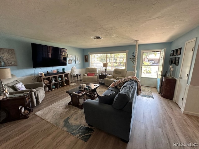 living room featuring a textured ceiling and light hardwood / wood-style flooring