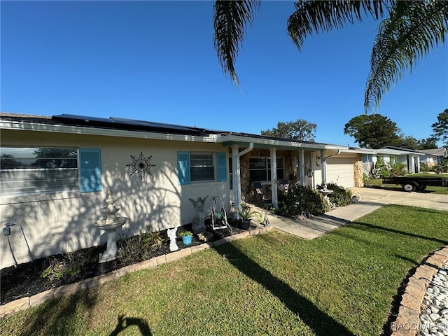 view of front of property featuring a front yard, solar panels, and a garage