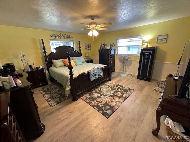 bedroom featuring a textured ceiling, light hardwood / wood-style floors, and ceiling fan