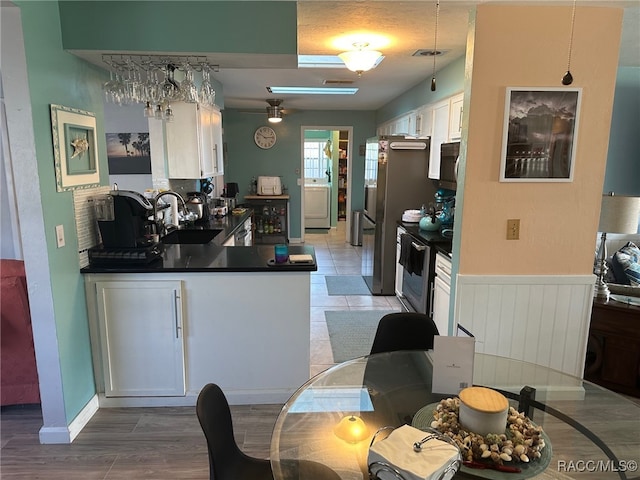 kitchen featuring white cabinets, light hardwood / wood-style flooring, stainless steel electric range oven, and sink