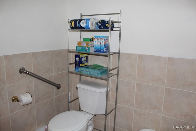 bathroom featuring toilet and tile walls