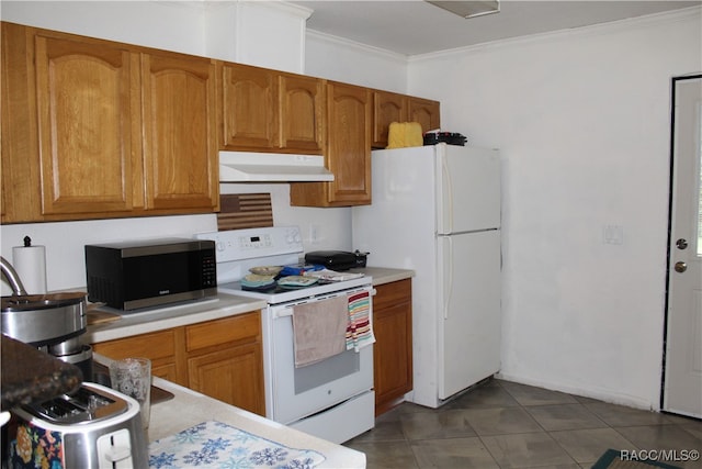 kitchen featuring white appliances, dark tile patterned flooring, and crown molding