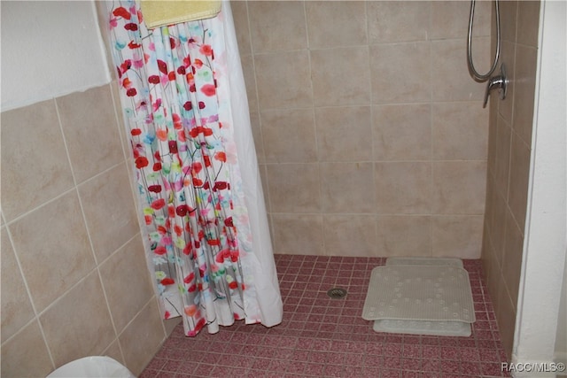 bathroom featuring walk in shower and tile walls