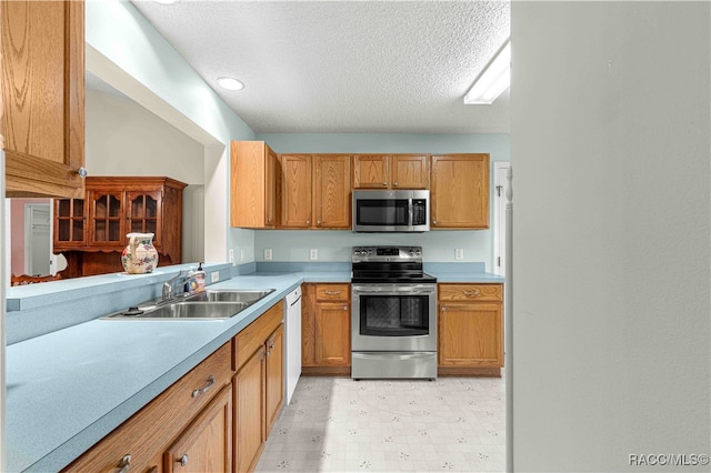 kitchen featuring a textured ceiling, sink, and stainless steel appliances