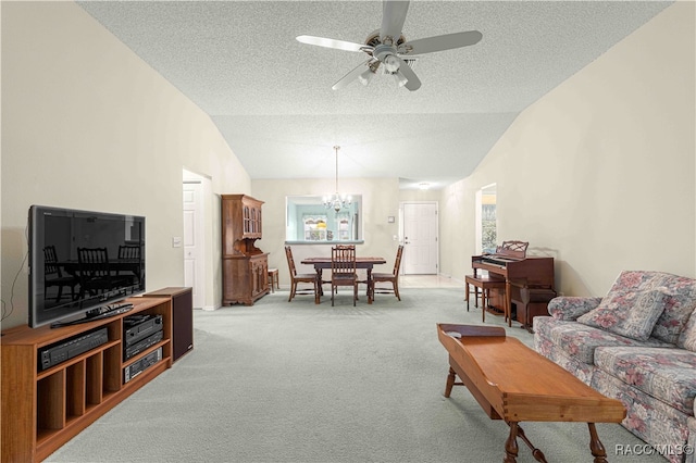 living room featuring a textured ceiling, ceiling fan with notable chandelier, carpet floors, and vaulted ceiling