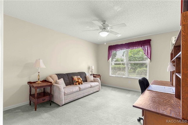 carpeted home office featuring ceiling fan and a textured ceiling