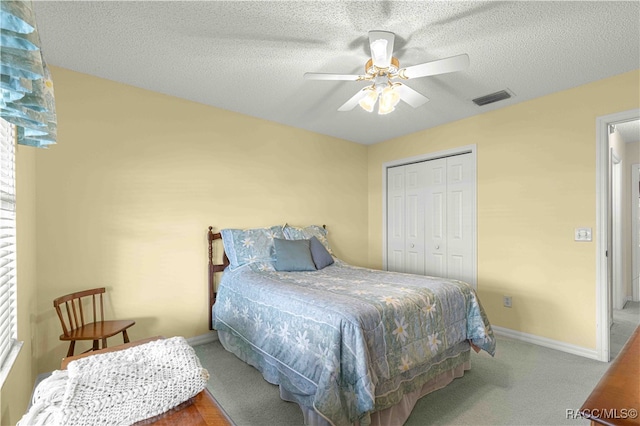 bedroom with carpet, ceiling fan, a textured ceiling, and a closet