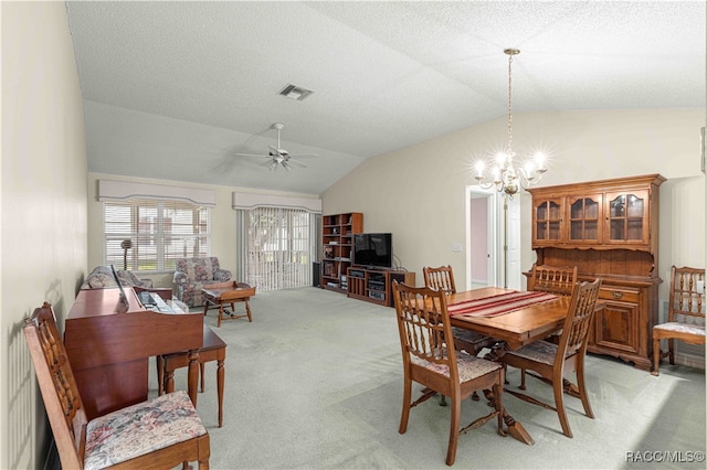 carpeted dining room featuring ceiling fan with notable chandelier, a textured ceiling, and vaulted ceiling