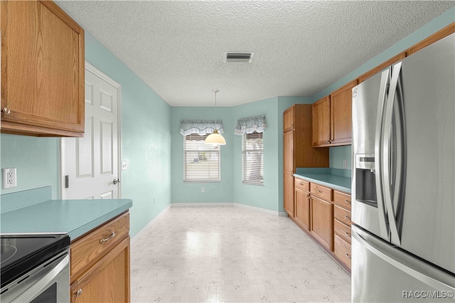 kitchen with hanging light fixtures, stainless steel appliances, and a textured ceiling