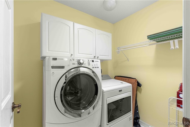 laundry area with washer and clothes dryer and cabinets