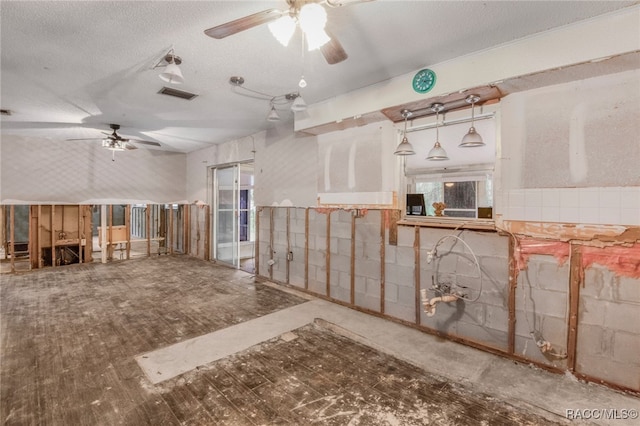 interior space featuring a textured ceiling and hanging light fixtures