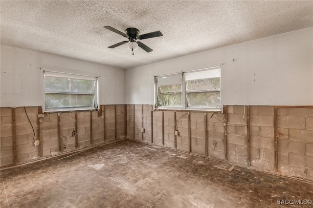 empty room with a textured ceiling and ceiling fan