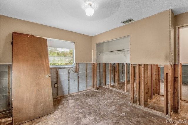 unfurnished room with a textured ceiling