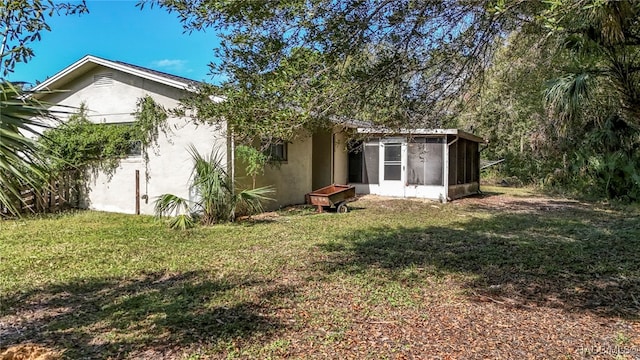 back of property with a sunroom and a yard