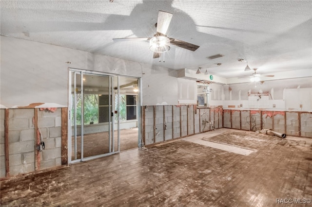 empty room with ceiling fan, hardwood / wood-style floors, and a textured ceiling