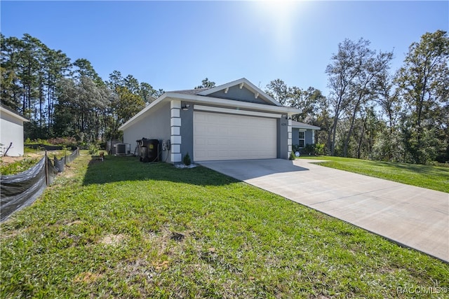 view of front of property with central AC unit, a front yard, and a garage