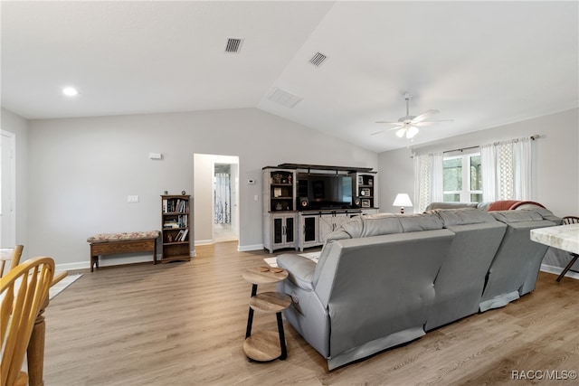 living room featuring ceiling fan, light hardwood / wood-style floors, and vaulted ceiling