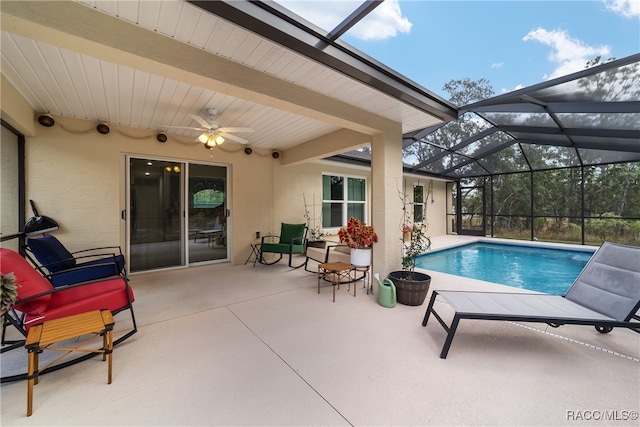 view of swimming pool with a lanai, ceiling fan, and a patio area