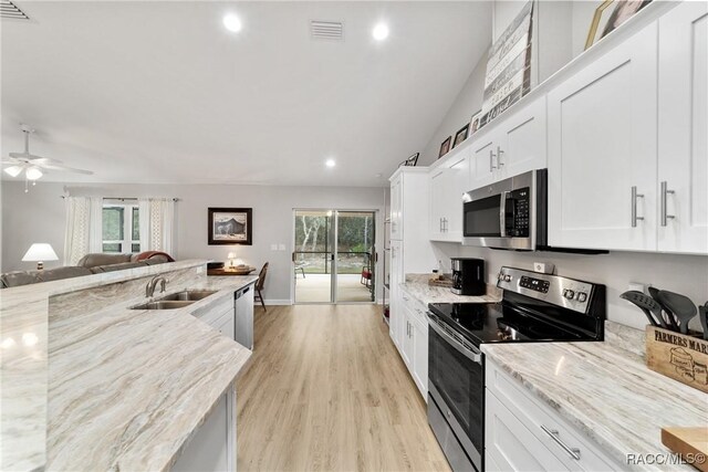 776 W Horizon Ln, Citrus Springs, FL 34434 - kitchen with appliances with stainless steel finishes, a sink, open floor plan, a ceiling fan, and white cabinets