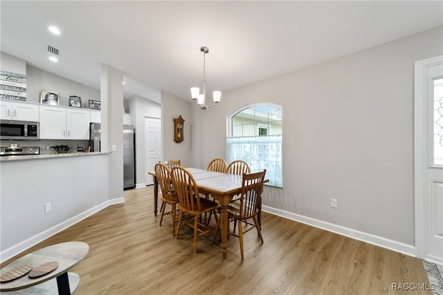 dining area with a notable chandelier and light hardwood / wood-style floors