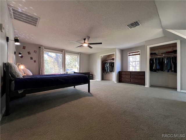 carpeted bedroom with ceiling fan, a textured ceiling, and vaulted ceiling