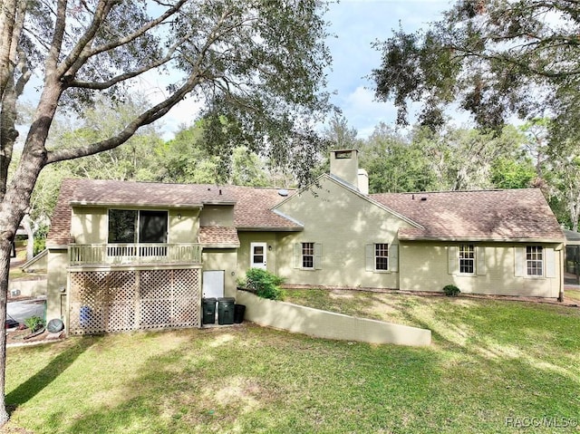 rear view of property featuring a lawn