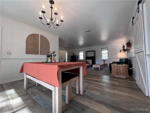 dining area with an inviting chandelier, dark wood-type flooring, and crown molding