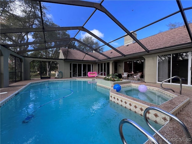 view of swimming pool featuring an in ground hot tub, a patio, and a lanai