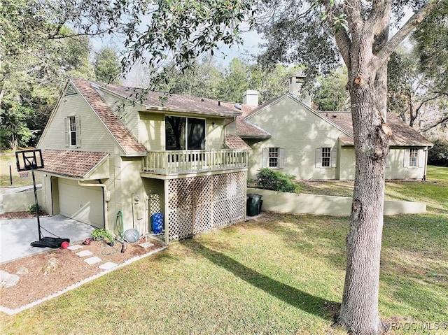 view of front of property featuring a garage, a wooden deck, and a front lawn