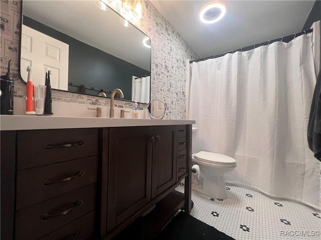 bathroom featuring tile patterned flooring, vanity, and toilet