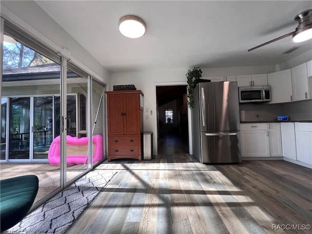 kitchen with tasteful backsplash, stainless steel appliances, ceiling fan, dark wood-type flooring, and white cabinetry