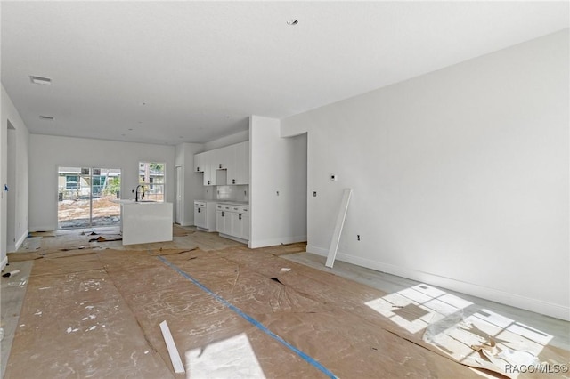 unfurnished living room featuring sink