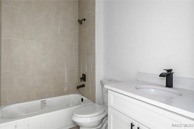 full bathroom featuring vanity, tiled shower / bath, and toilet