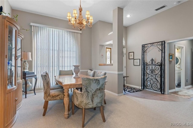 dining room with baseboards, visible vents, a notable chandelier, and light colored carpet