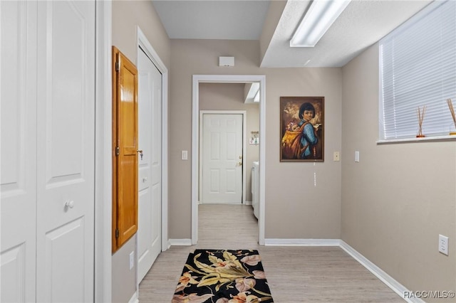 doorway to outside featuring light wood finished floors and baseboards