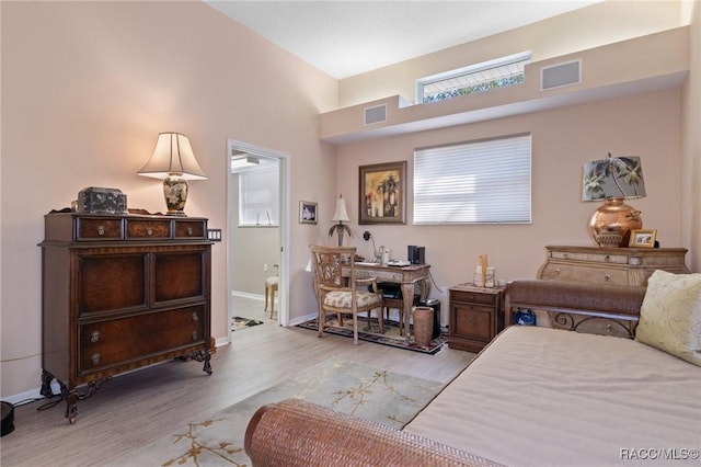 bedroom featuring visible vents, baseboards, and wood finished floors