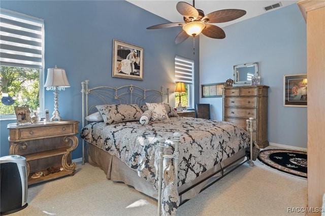 carpeted bedroom featuring a ceiling fan, visible vents, and baseboards