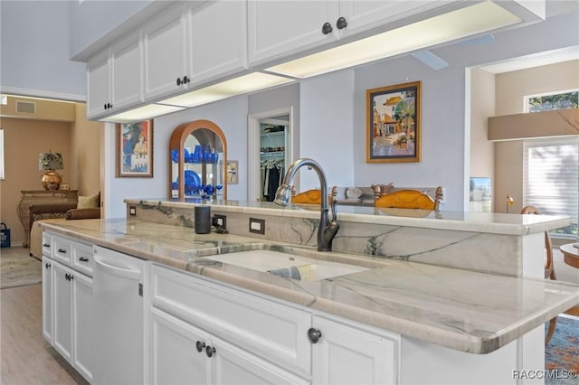 kitchen with visible vents, dishwasher, a sink, and white cabinetry