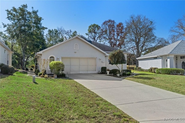 view of front of house featuring a garage, concrete driveway, a front lawn, and stucco siding