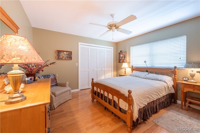 bedroom with ceiling fan, light hardwood / wood-style floors, and a closet