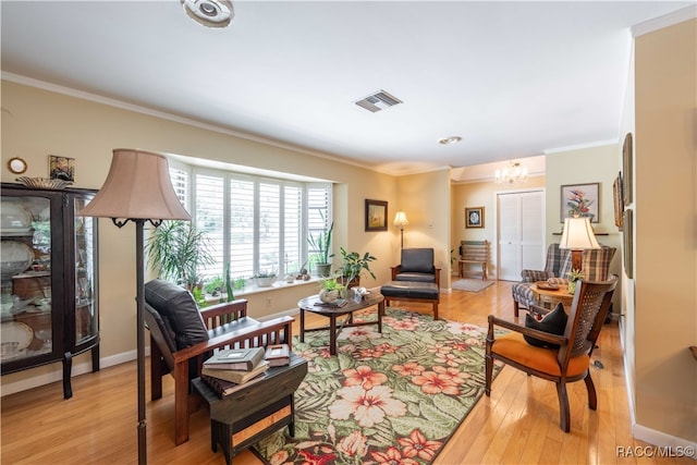 sitting room featuring a notable chandelier, crown molding, and light hardwood / wood-style flooring