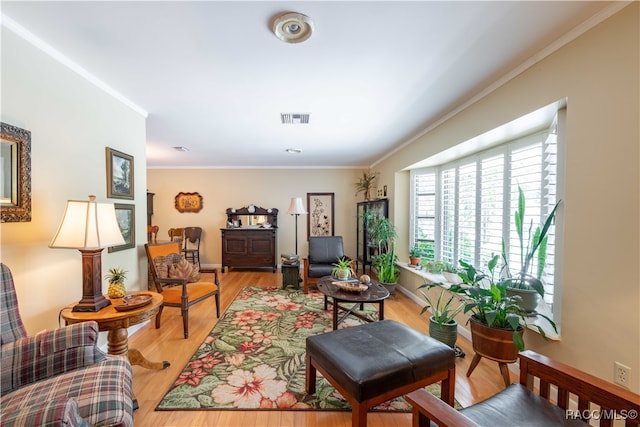 living area with light wood-type flooring and crown molding