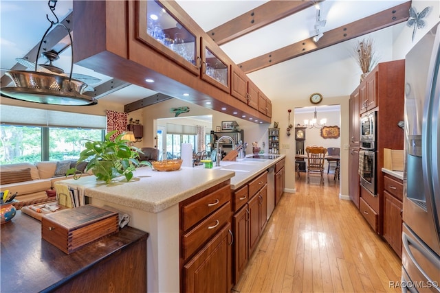 kitchen with sink, stainless steel appliances, an inviting chandelier, beamed ceiling, and light hardwood / wood-style floors