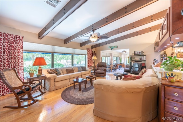 living room with vaulted ceiling with beams, ceiling fan, plenty of natural light, and light wood-type flooring